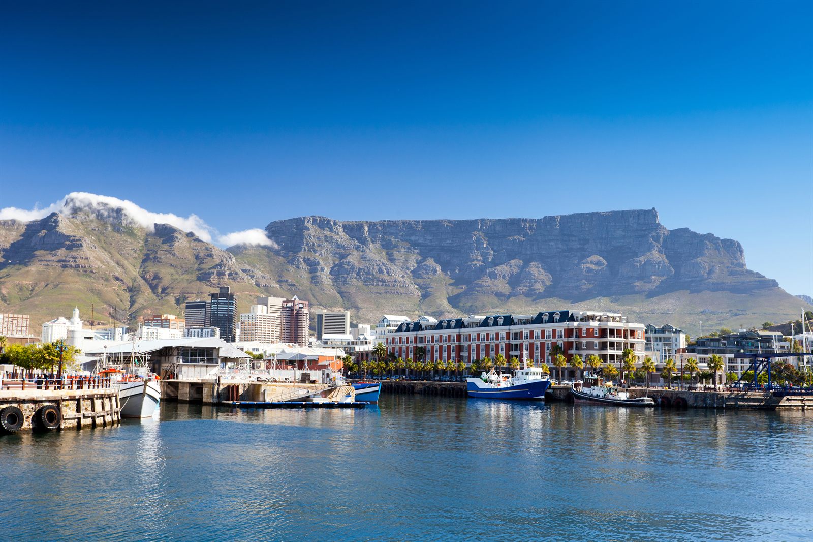 V&A Waterfront buildings and moored boats in Cape Town with Table Mountain behind