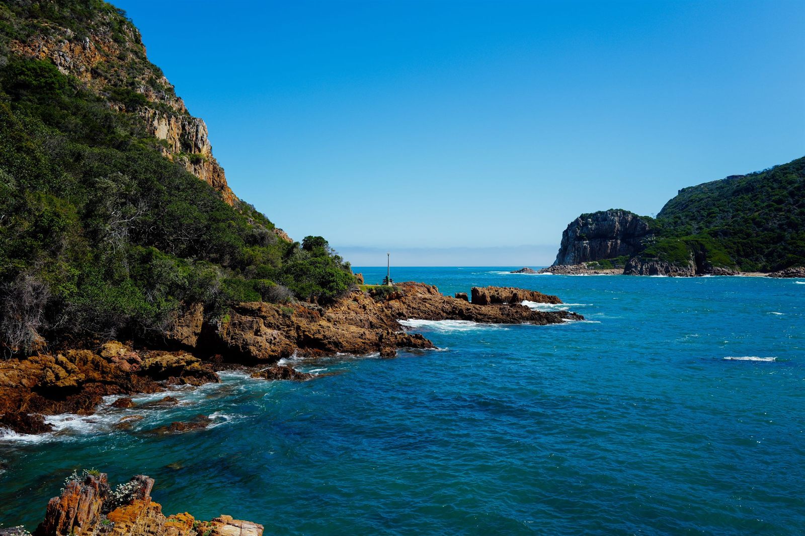 Rocky headlands and deep blue water at the mouth of the Knysna lagoon